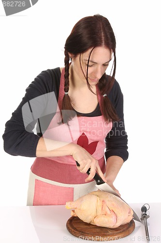 Image of beautiful housewife cutting chicken 