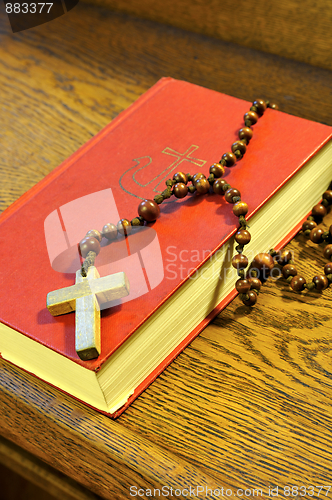 Image of Hymnal  book and wooden rosary bead