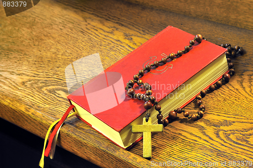 Image of Hymnal  book and wooden rosary bead
