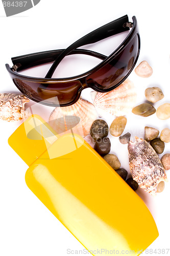 Image of sunglasses, shells and lotion