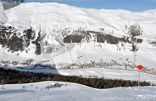 Image of View down ski slope on chairlift station, valley and impressive mountains