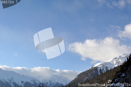 Image of Mountain panorama with trees, snow and clouds