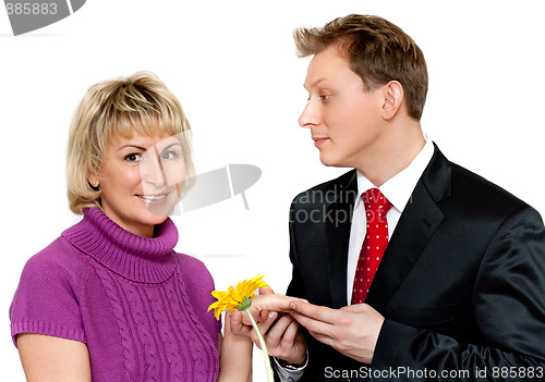 Image of Man in suit presents daisywheel to woman