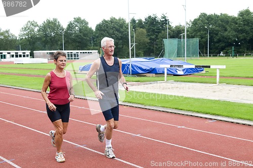 Image of Senior Couple Running On A Track