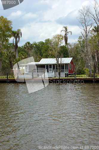 Image of small red cottage on water