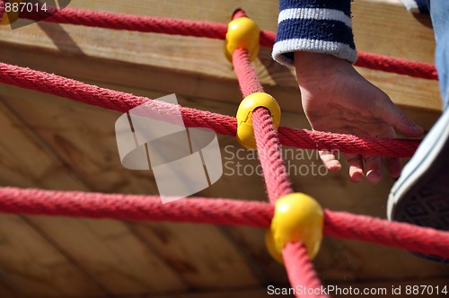 Image of Boy climbing the ropes on playground