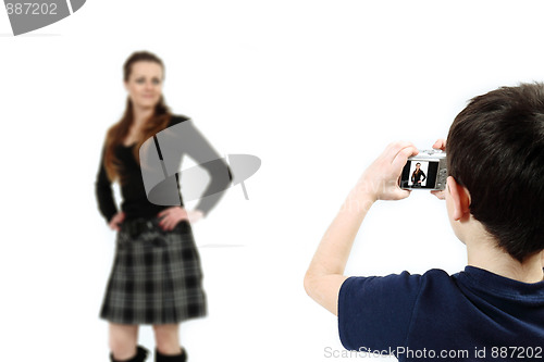 Image of Young boy with digital camera shooting girl