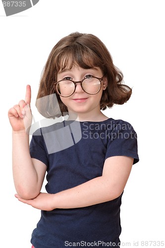 Image of Little girl in round spectacles raising finger in attention gesture isolated