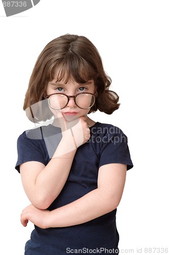 Image of Thoughtful little girl in round spectacles rests her head on her hand isolated