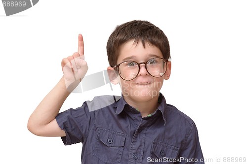 Image of Little boy in round spectacles raising finger in funny attention gesture isolated