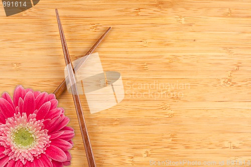 Image of Gerber Daisy and Chopsticks on a Bamboo Background