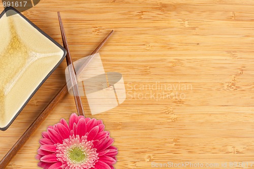 Image of Gerber Daisy, Chopsticks and Dish on a Bamboo Background