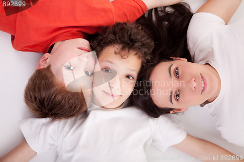 Image of boys with woman, lying on the floor with heads together