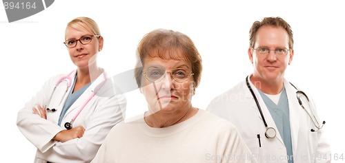 Image of Concerned Senior Woman with Doctors Behind
