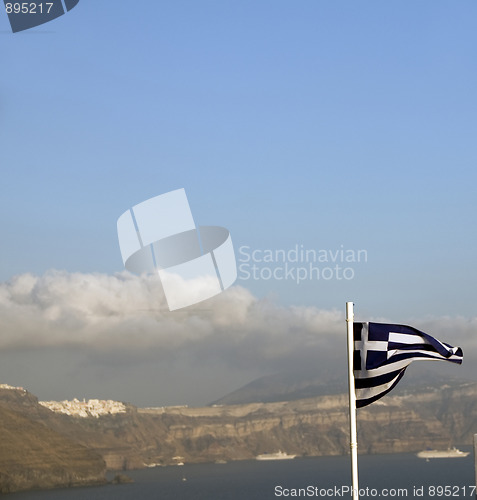 Image of flag of Greece flying over the caldera Oia Santorini