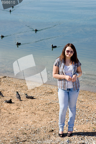 Image of A young girl with brown hair standing on the beach