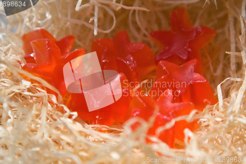 Image of Red soap in the form of stars on a straw background