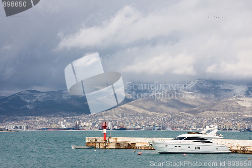 Image of yacht and boat near the pier with the lighthouse