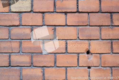 Image of Old red brick wall with two holes and one yellow brick