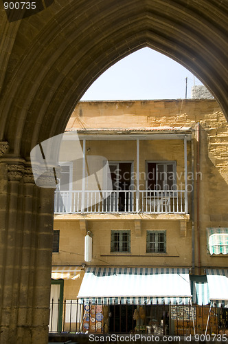 Image of street scene of retail store through pillars arches of ancient s