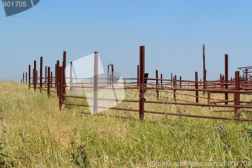 Image of Rusty fence of the empty cattle-pen in bright summer day