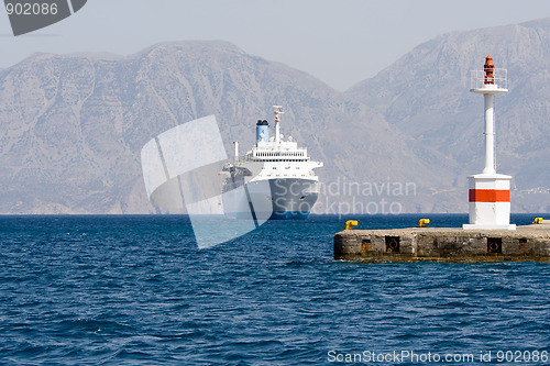 Image of Tourist cruise sea liner sails to lightship in rocky bay