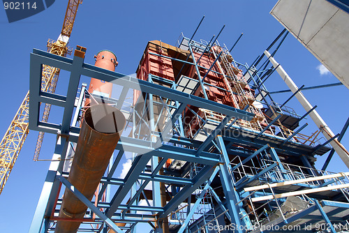 Image of cranes and beams on construction of industrial factory 