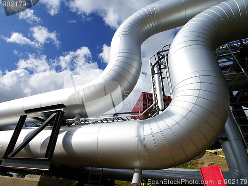 Image of industrial pipelines on pipe-bridge against blue sky 