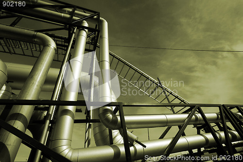 Image of industrial pipelines on pipe-bridge against sky  