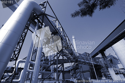 Image of industrial pipelines on pipe-bridge against blue sky 