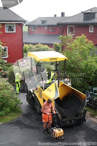 Image of Workers spreading asphalt