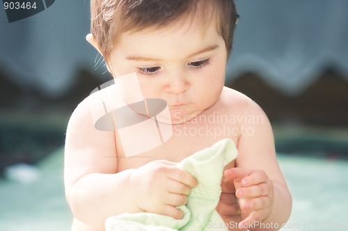 Image of Cute baby playing with towel