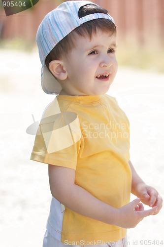 Image of Little boy in yellow shirt looking sideways