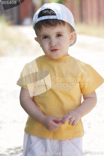 Image of Little boy in yellow shirt and cap