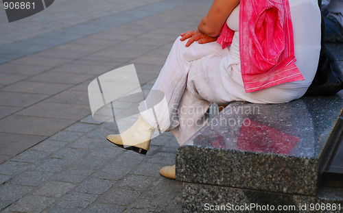 Image of Woman sitting in a stone bench