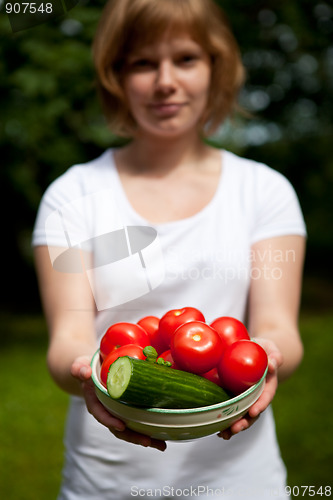 Image of Girl holding a bowl of tomato and cucumber