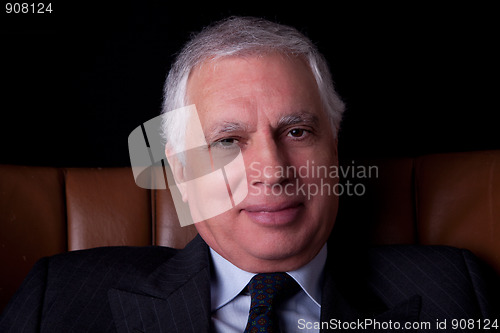 Image of old businessman  seated on a chair 