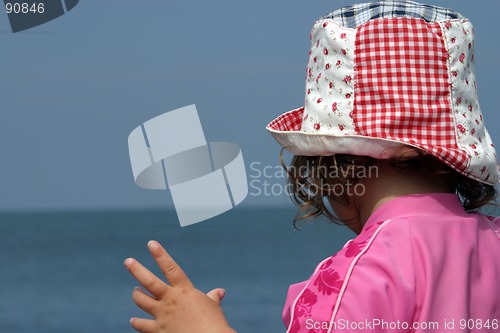 Image of Young girl in sunhat on beach