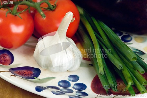 Image of Tomatoes, garlic and scallions on a plate.