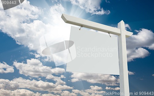 Image of Blank Real Estate Sign over Clouds and Blue Sky