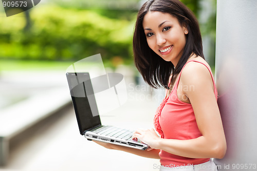 Image of Woman on the phone and working on her laptop