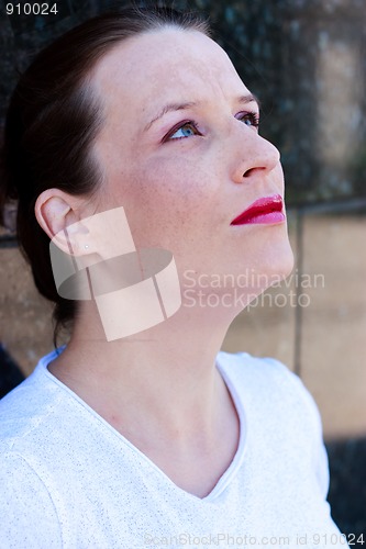 Image of Beautiful young green-eyed girl looking up