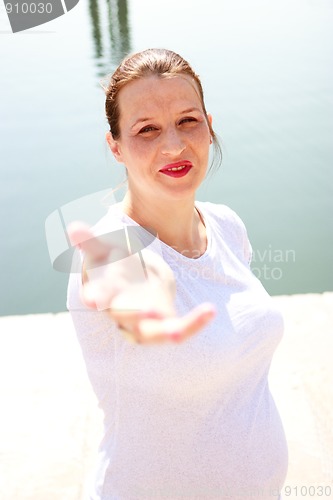 Image of Beautiful young pregnant girl reaching hand