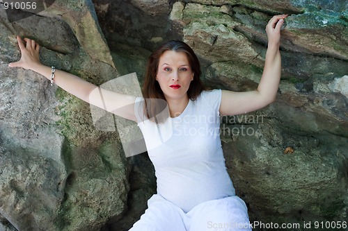 Image of Beautiful young pregnant girl with stones in the background