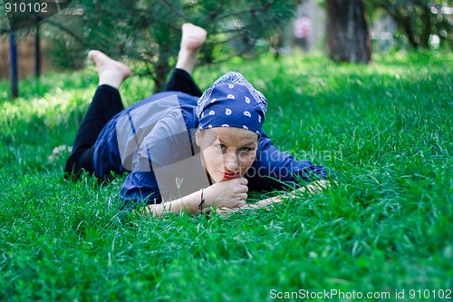 Image of Beautiful young woman lying in the grass