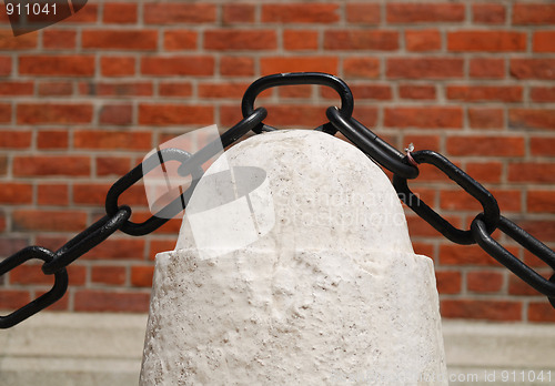 Image of ancient rusty chain and stone column