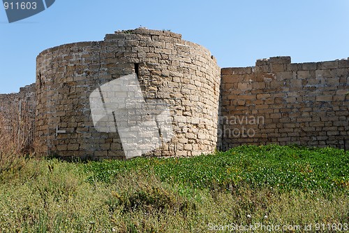 Image of Round tower and wall of medieval castle among grass