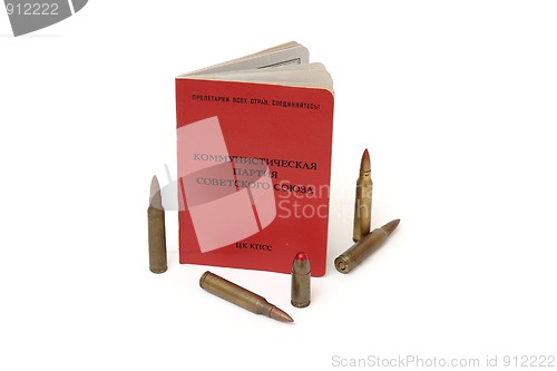 Image of Soviet communist party membership card stands surrounded by cartridges isolated