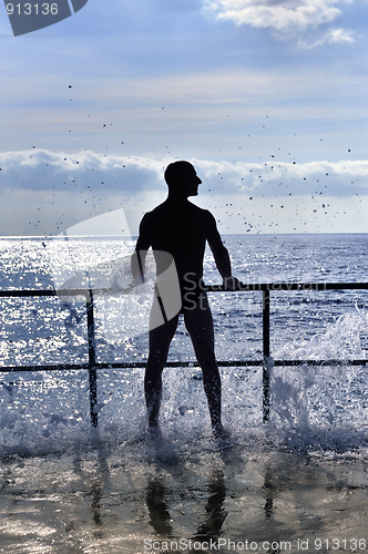 Image of Silhouette of young man standing at the seaside