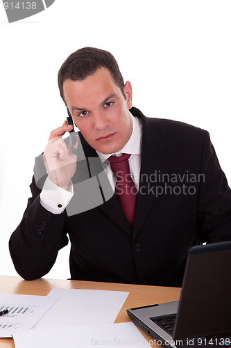 Image of businessman setting a desk talking on the phone